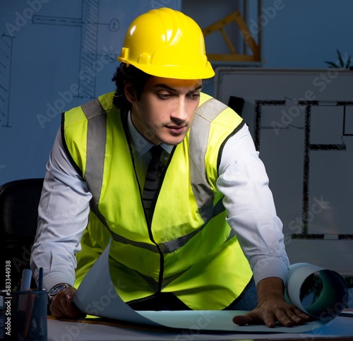 Young construction architect working on project at night