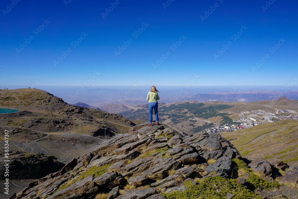 Fototapeta premium Young Caucasian woman dressed in jeans and sweatshirt enjoying the views of the Alpujarra valleys of Granada