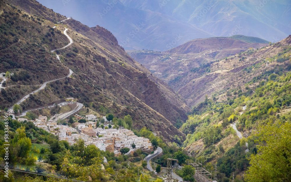Panoramic view of a valley in the Alpujarras of Granada with a white village in the background