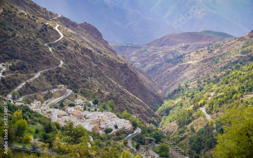 Panoramic view of a valley in the Alpujarras of Granada with a white village in the background