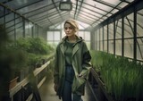 Portrait of a young woman farmer in a greenhouse. Concept of regenerative farming. Generative AI.