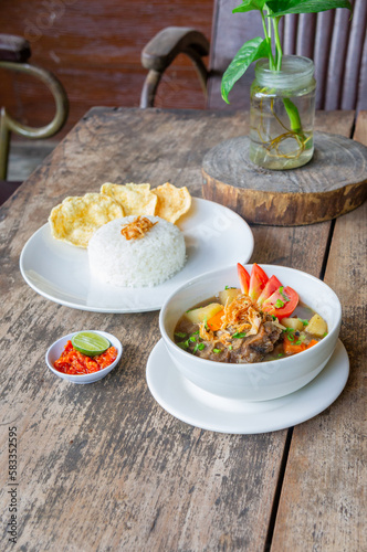 Delicious Oxtail Soup or Soup Buntut Served with Chili Sauce or Sambal and Steam Rice