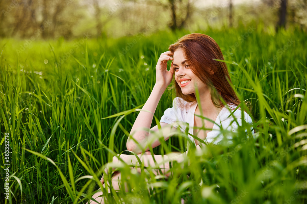 adorable woman sitting in nature resting in tall grass adorable woman sitting in nature resting in tall grass
