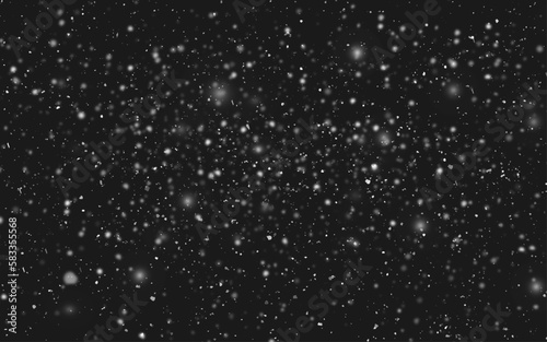 Snowstorm texture. Bokeh lights on black background, shot of flying snowflakes in the air