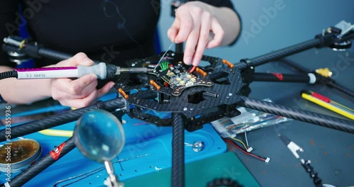 Engineer working on racing fpv drone combat kamikaze bomber in workshop.
