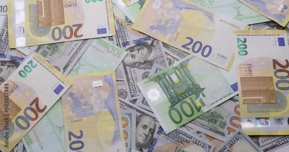 Cash USD and EURO money background - One Two hundred euro and dollar banknotes rotate in close up macro view Cash USD and EURO money background - One Two hundred euro and dollar banknotes rotate in close up macro view