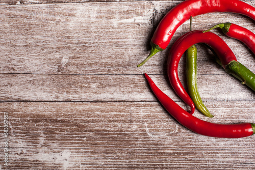 Red and green spicy pepper on wooden background in studio photo