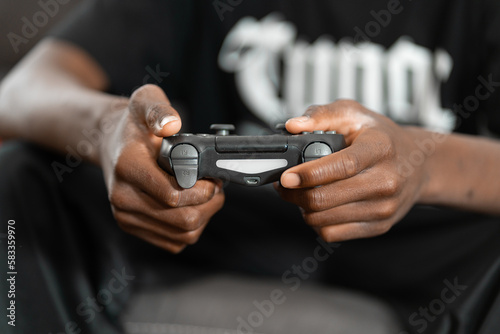 ritratto delle mani di un giovane ragazzo nero che tiene la joystick in mano photo