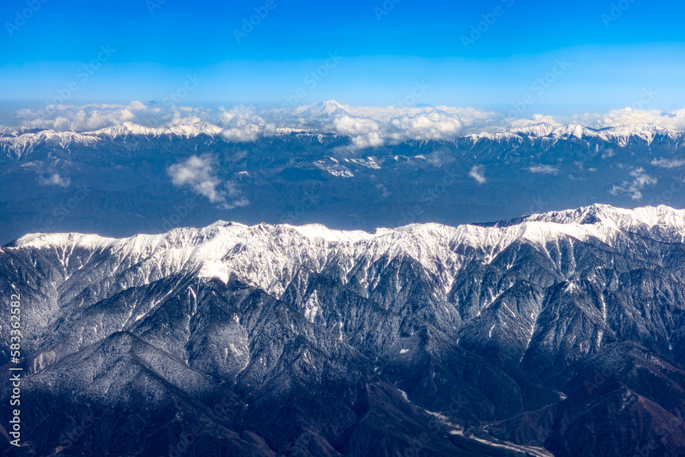 飛行機から見た南アルプスと富士山の雪景色