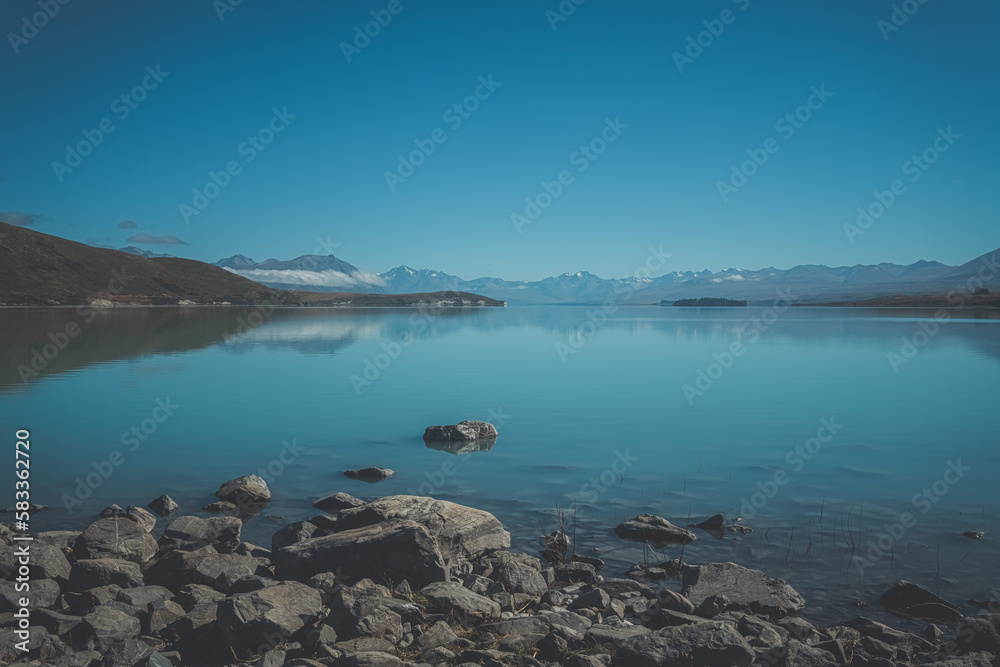 Stones in large green lake, New Zealand. Lake Wanaka