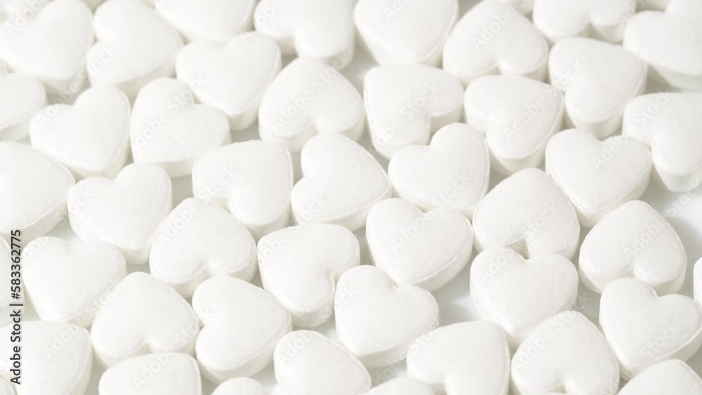 Macro white heart shape drugs, closeup medical pills rotating, medicine concept Macro white heart shape drugs, closeup medical pills rotating, medicine concept
