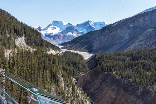 Wilcox Peak from the Columbia Icefield Skywalk in Jasper Park in Canada above a glacier with a glass railing in the foreground and a clear blue sky in the background