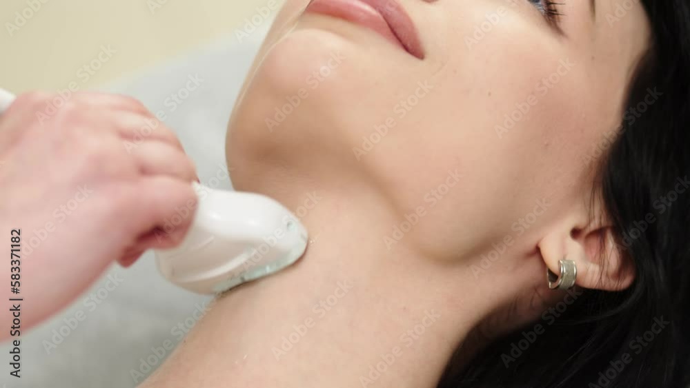 Ultrasound diagnosis of the thyroid gland of a young woman in the clinic. A female doctor holds an ultrasound probe along the patient's neck. Health concept. Ultrasound diagnosis of the thyroid gland of a young woman in the clinic. A female doctor holds an ultrasound probe along the patient's neck. Health concept.