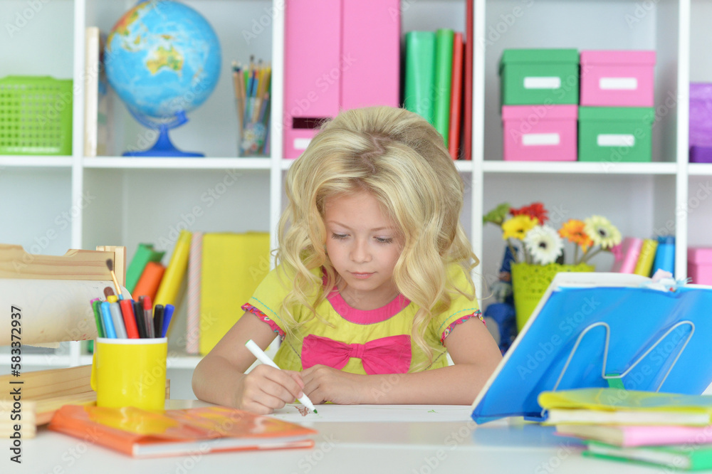 little girl studying at home at the table little girl studying at home at the table
