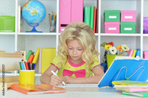 little girl studying at home at the table