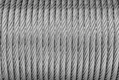 The texture of a new stainless steel cable wrapped in a spool. Abstract background.