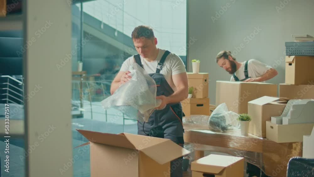 Workers of Moving Company With Uniforms Carefully Packing and Carrying Boxes. Shipping and Packaging Business Occupation Service Company. Preparation for a Long Trip, Transportation of Things Workers of Moving Company With Uniforms Carefully Packing and Carrying Boxes. Shipping and Packaging Business Occupation Service Company. Preparation for a Long Trip, Transportation of Things