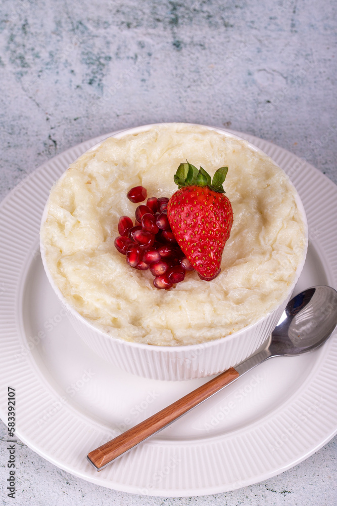 Gullac dessert. Traditional Ramadan dessert. Pomegranate and strawberry gullac dessert in bowl Gullac dessert. Traditional Ramadan dessert. Pomegranate and strawberry gullac dessert in bowl