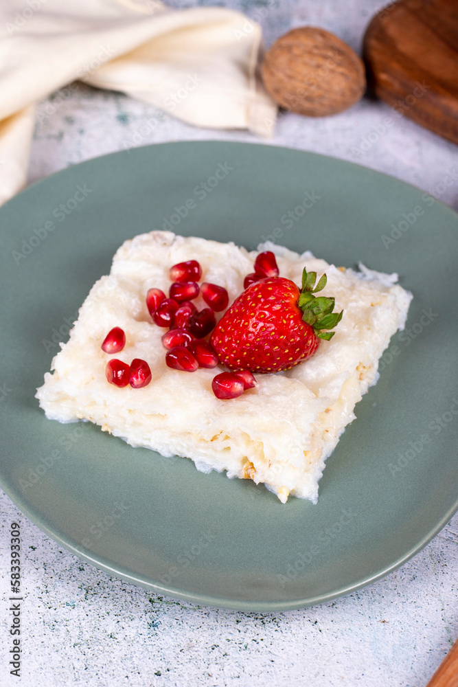 Gullac dessert. Traditional Ramadan dessert. Gullac dessert with pomegranate and strawberry on the plate. Close up Gullac dessert. Traditional Ramadan dessert. Gullac dessert with pomegranate and strawberry on the plate. Close up