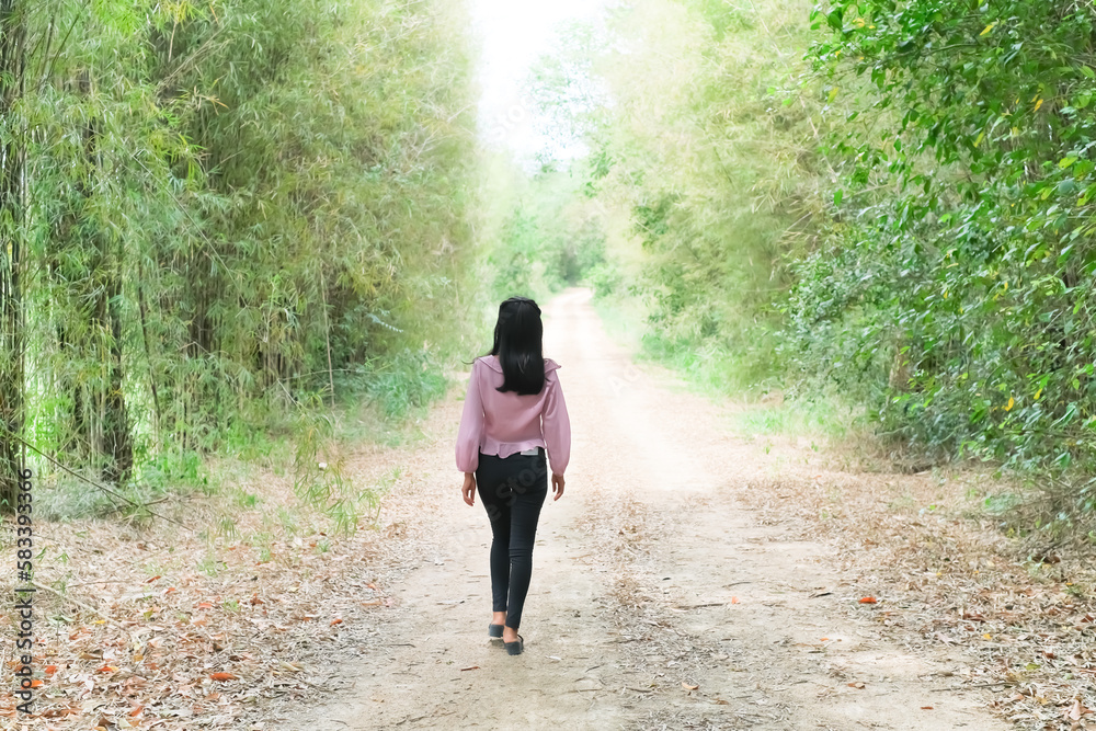 Alone Young Women Walking on Road Away in Forest at Countryside,Grill on Path Way in Park Landscape,Concept for Broken Heart or Tourism Vacation Travel Summer Autumn Holidays Concept. Alone Young Women Walking on Road Away in Forest at Countryside,Grill on Path Way in Park Landscape,Concept for Broken Heart or Tourism Vacation Travel Summer Autumn Holidays Concept.