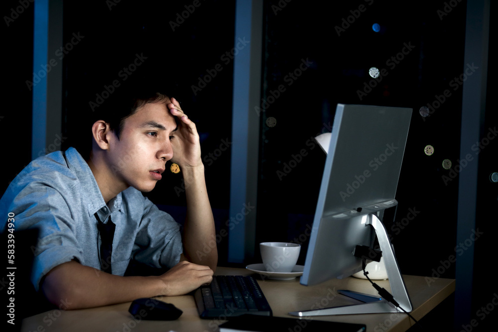 Tired staff officer put head on hands during work with desktop computer, feel sleepy after has overwork project overnight but try to not fall asleep, exhausted businessman work hard overtime at night. Tired staff officer put head on hands during work with desktop computer, feel sleepy after has overwork project overnight but try to not fall asleep, exhausted businessman work hard overtime at night.