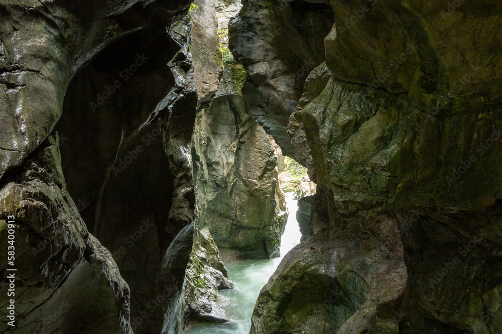 Wild water flowing in between narrow rocky cliffs inside Austria's Lammer River Gorge