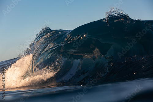 close up wave crashing on a shallow reef at sunrise