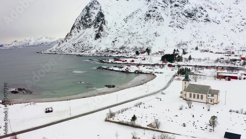 4k drone forward video (Ultra High Definition) of Valberg village, Norway, Europe. Snowy winter scene of Lofoten Islands. Beautiful morning view of Velberg church. photo