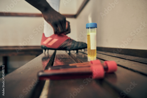 Rugby, blood and urine sample in a locker room for sports regulations or anti doping testing. Fitness, health and medical with an athlete getting ready after a drug test for an illegal substance photo