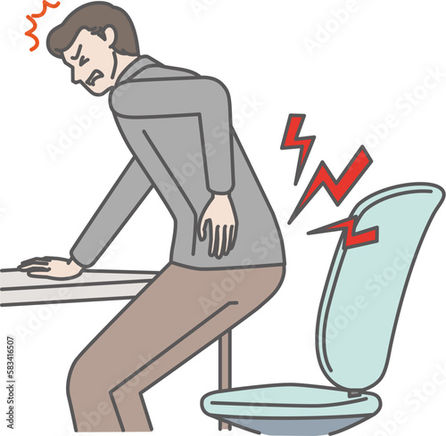 椅子から立ち上がる時、腰痛で顔をしかめる男性