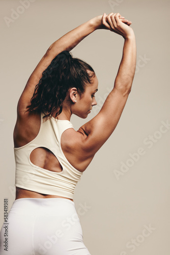 Rearview of an athletic woman stretching her arms in a muscle-toning exercise photo