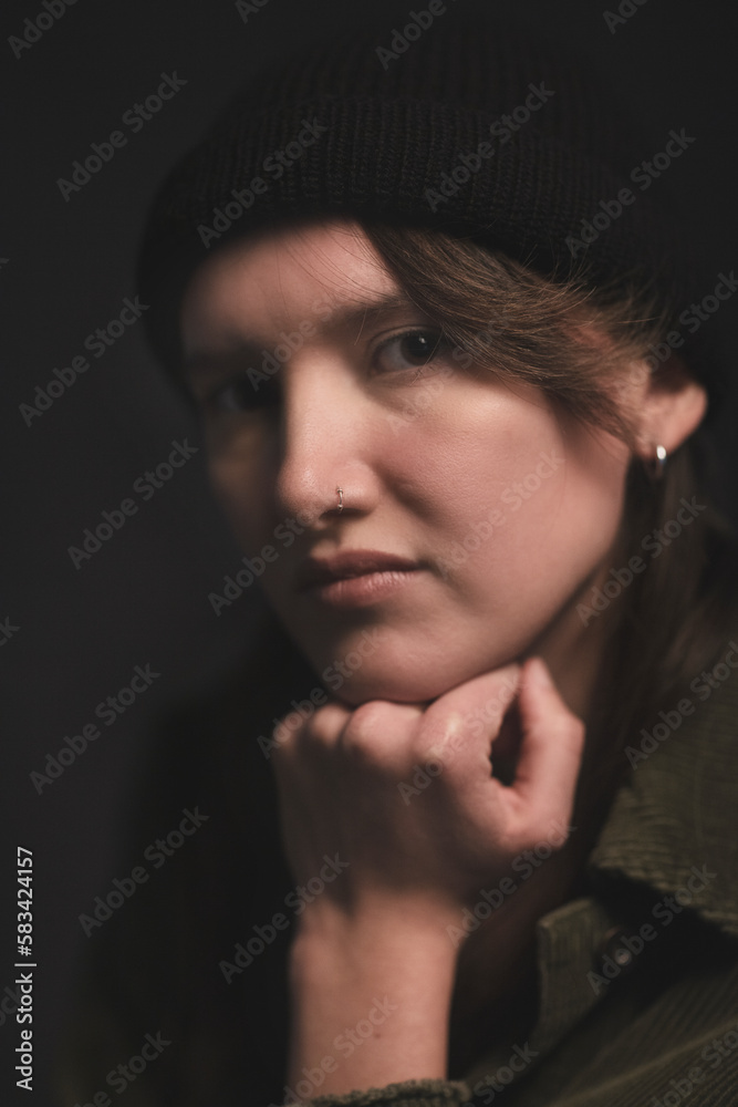 Studio Image of mid twenties girl, with half shaved head and with hat on Studio Image of mid twenties girl, with half shaved head and with hat on