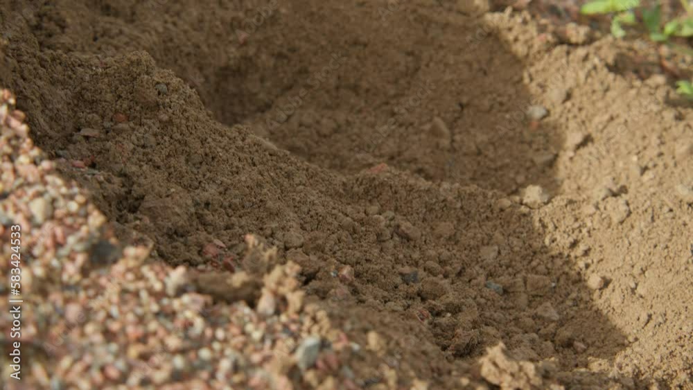 Farmer shoveling dirt with ground crumbling around it Farmer shoveling dirt with ground crumbling around it
