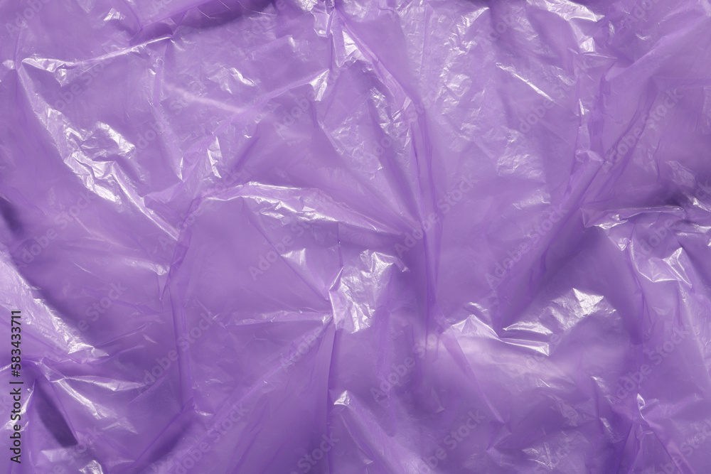 Obraz premium Crumpled purple plastic bag as background, top view