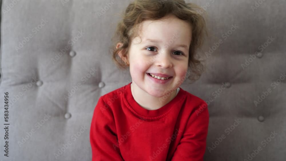 Funny little girl talking and smiling child looking at camera at home, happy childhood Funny little girl talking and smiling child looking at camera at home, happy childhood