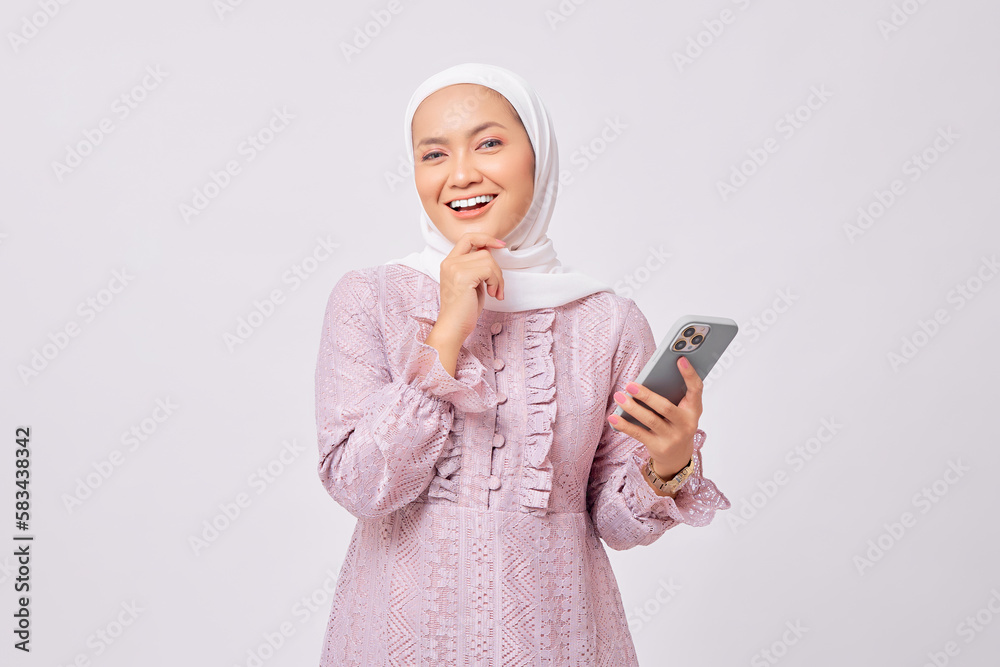 Φωτογραφία Smiling beautiful young Asian Muslim woman wearing hijab and purple dress holdin