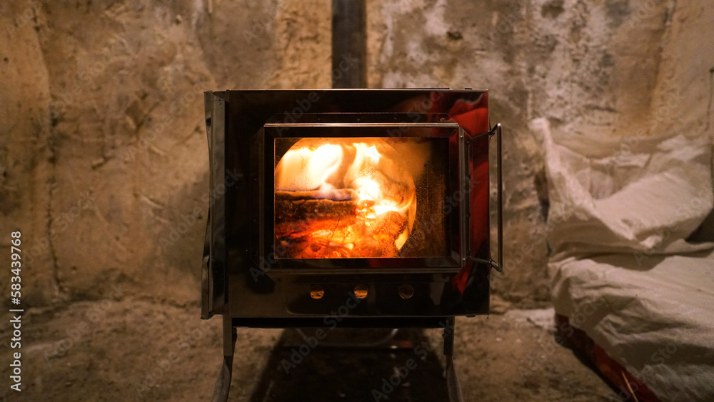 A fire is burning in a camping stove with a glass door. The process of  smoldering
