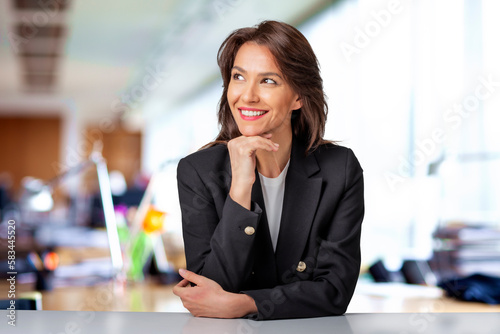Executive professional female wearing blazer and cheerful smiling while sitting at the office