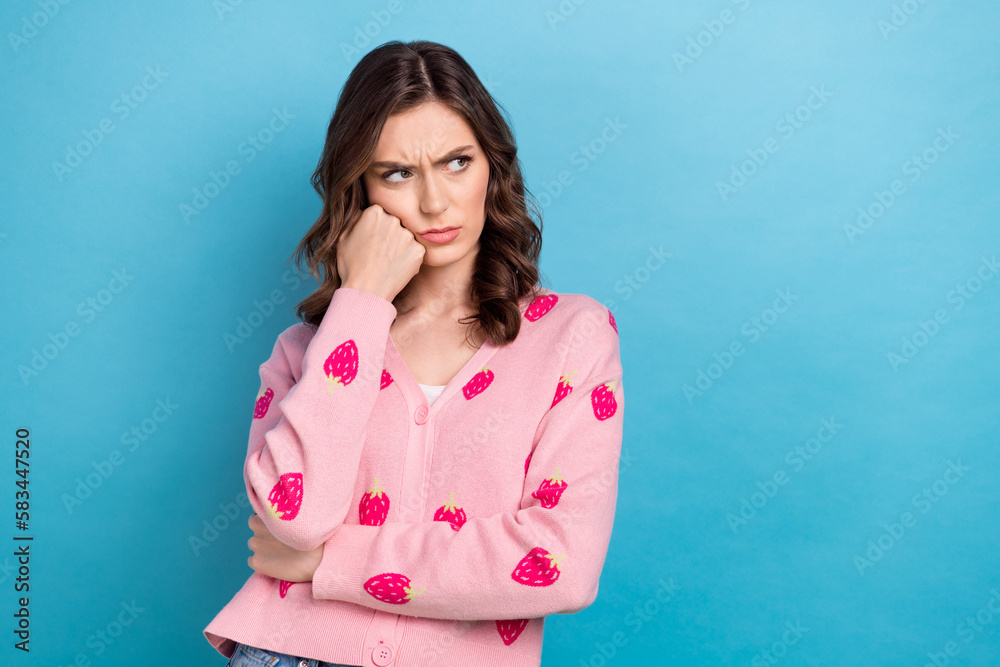 Photo of bored funny woman wear pink cardigan arm fist cheek looking emtpy space isolated blue color background Photo of bored funny woman wear pink cardigan arm fist cheek looking emtpy space isolated blue color background