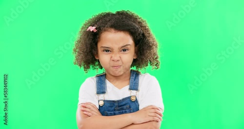 Child, angry and face with arms crossed on green screen with attitude, problem or frustrated in studio. Black kid or girl with mad, grumpy and upset or annoyed facial expression with brat tantrum photo