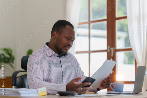 Smiling American African Banker or Accountant makes financial report and studies annual figures, analyzes profits. Accountant checks status of financial
