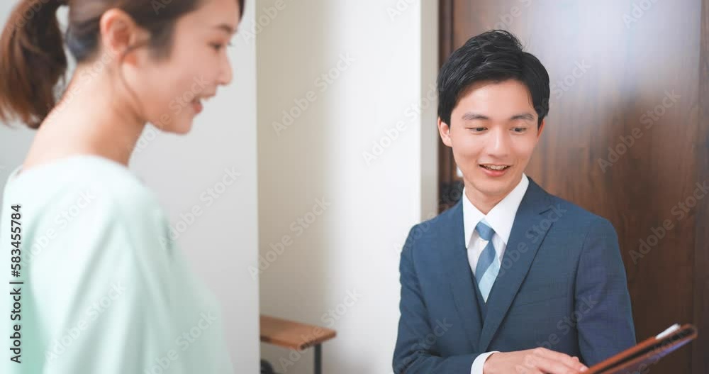 訪問販売をする若いビジネスマンと主婦 訪問販売をする若いビジネスマンと主婦