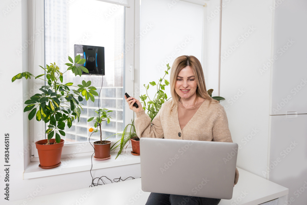 Woman cleaning windows at home with robotic cleaner. Woman cleaning windows at home with robotic cleaner.