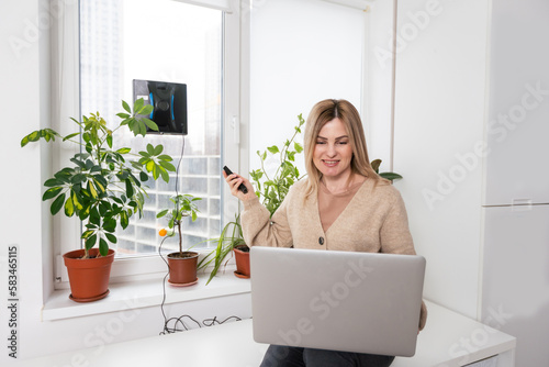 Woman cleaning windows at home with robotic cleaner. © Angelov