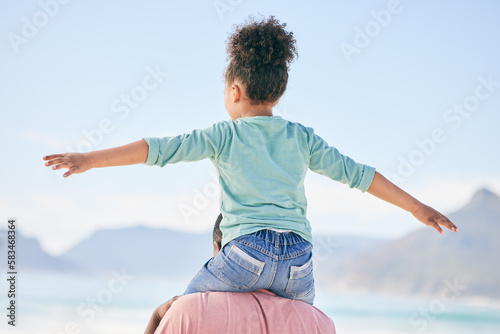 Beach, black man with child on shoulders from back on playful family holiday in Australia with freedom and fun. Travel, fun and happy father and girl playing, flying and bonding together on vacation.