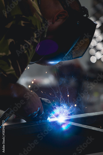 Industry worker welding iron pieces at work