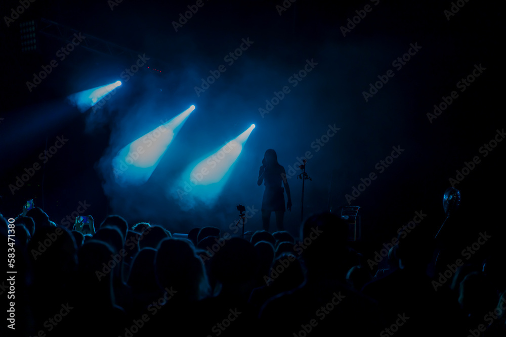 stage lights with smoke and a crowd of spectators