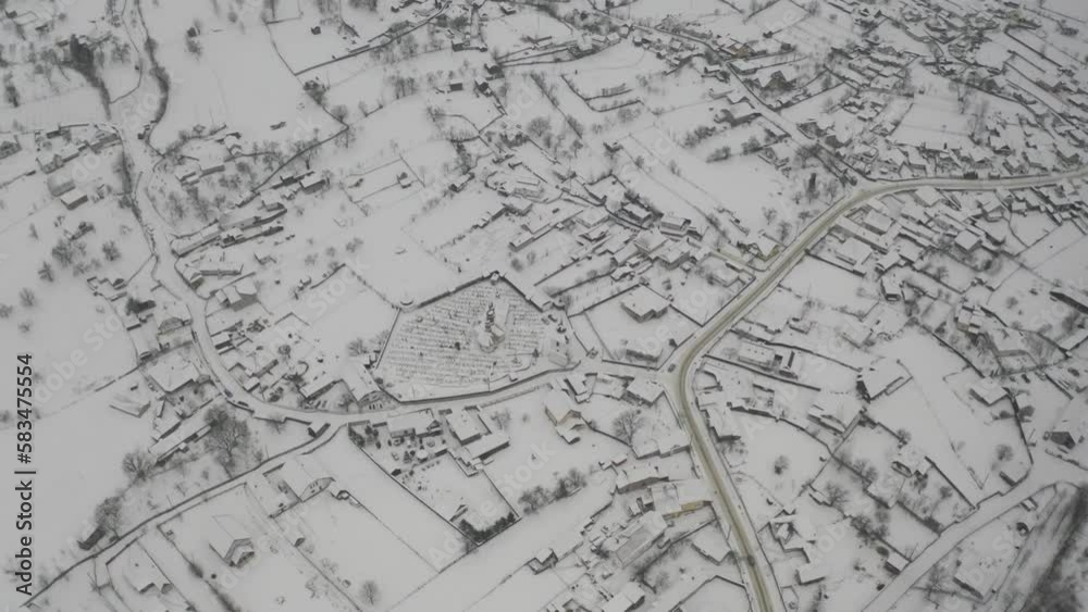 Reverse zoom drone view of a snow covered town with a glimpse of mountains in the background. Reverse zoom drone view of a snow covered town with a glimpse of mountains in the background.