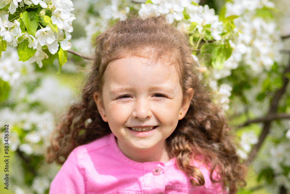 portrait happy little beautiful cute girl smelling flowers of blossoming apple tree. concept of spring mood child, summer. baby summer time portrait happy little beautiful cute girl smelling flowers of blossoming apple tree. concept of spring mood child, summer. baby summer time