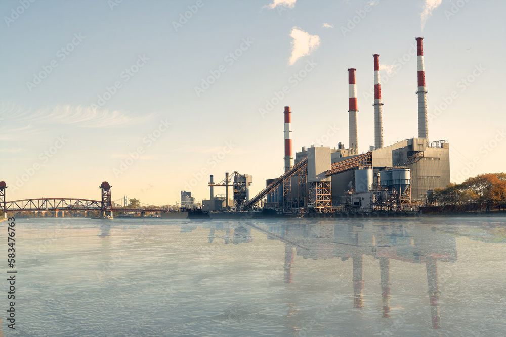 Industrial plant with chimneys reflecting in river